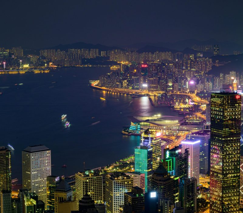 Stunning nighttime view of Hong Kong Island with illuminated skyscrapers and vibrant cityscape across Victoria Harbor.